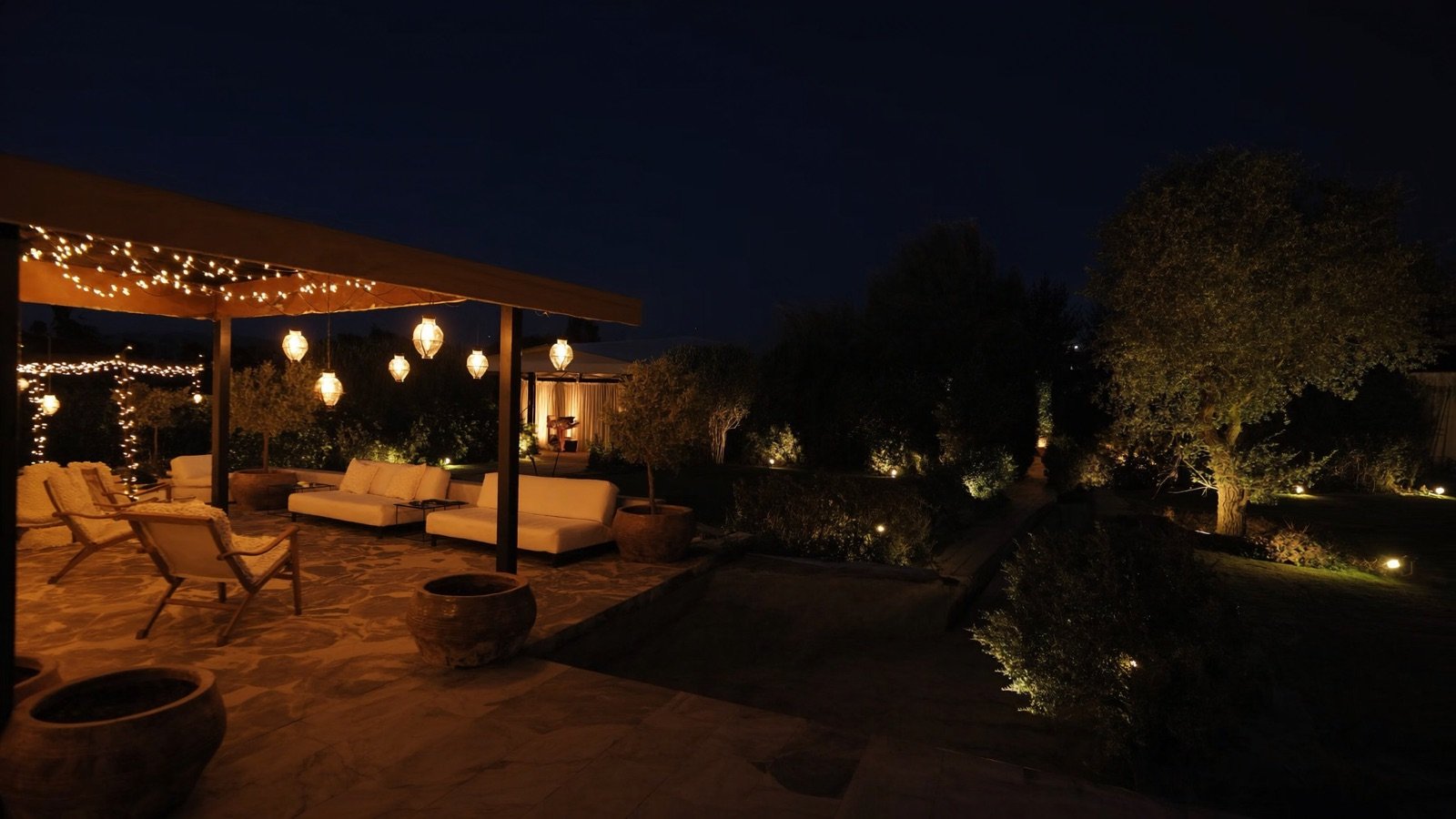 Terraza del jardín iluminada de noche con faroles